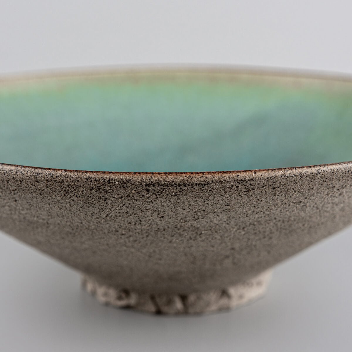 Underside view of artisanal ceramic plate with hand-carved foot.