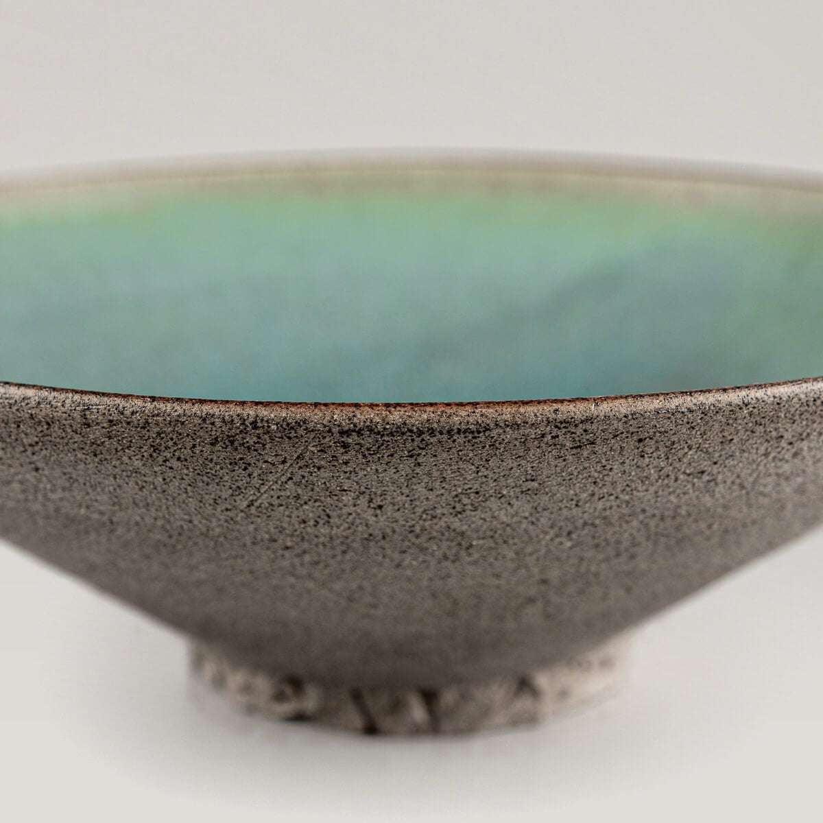 Underside view of artisanal ceramic plate with hand-carved foot.