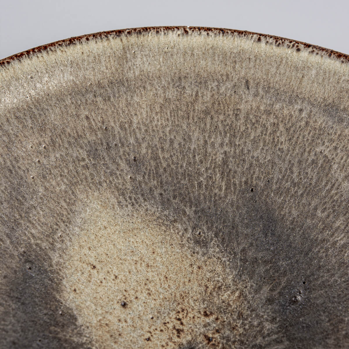 Unique ceramic dinner plate showcasing raw clay exterior and refined glaze interior.