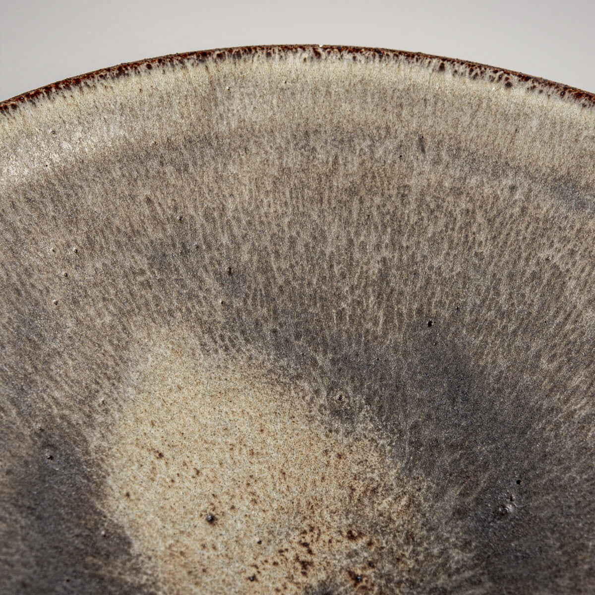 Unique ceramic dinner plate showcasing raw clay exterior and refined glaze interior.