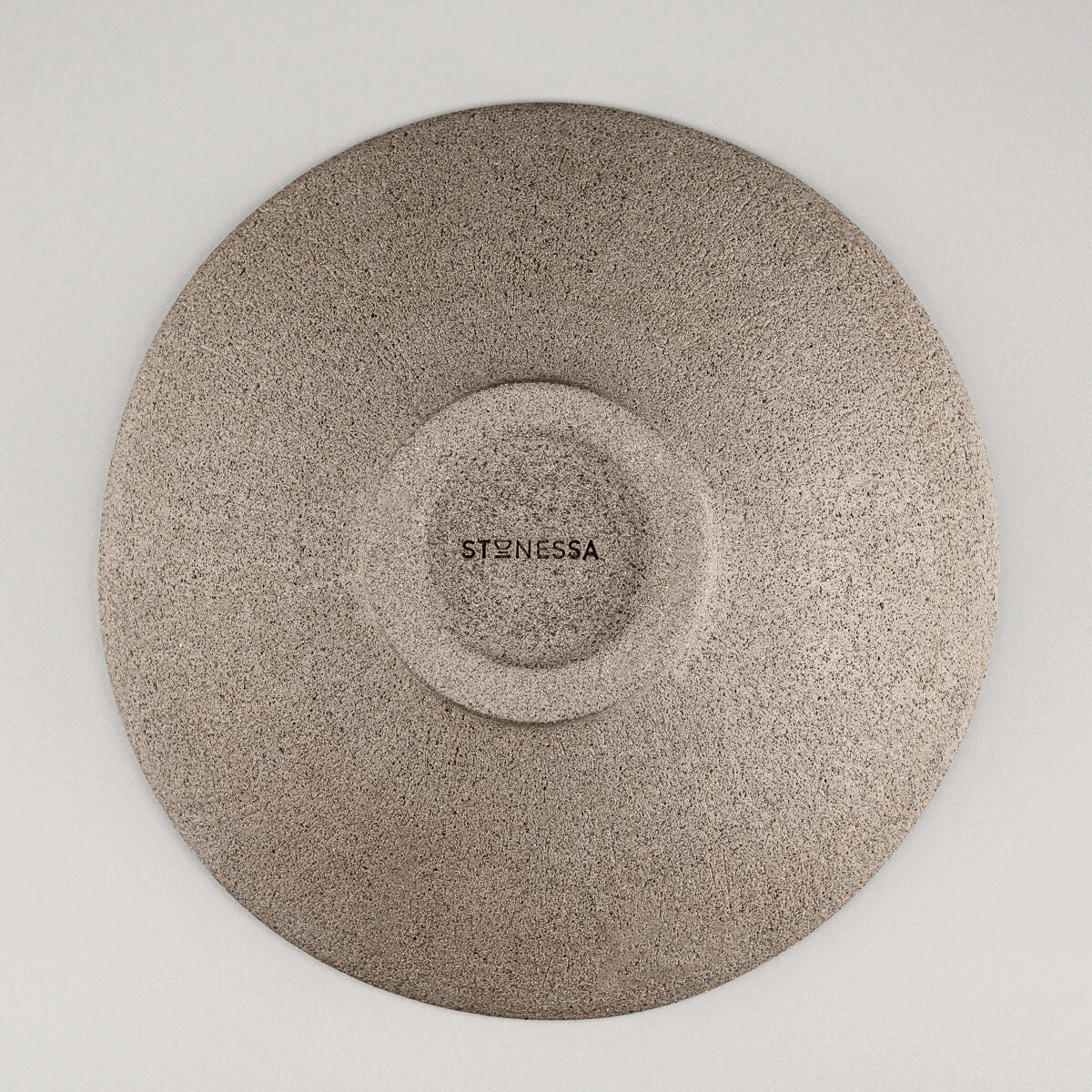 Artisan ceramic dinner plate base view showcasing unglazed textured clay and embossed maker’s mark.