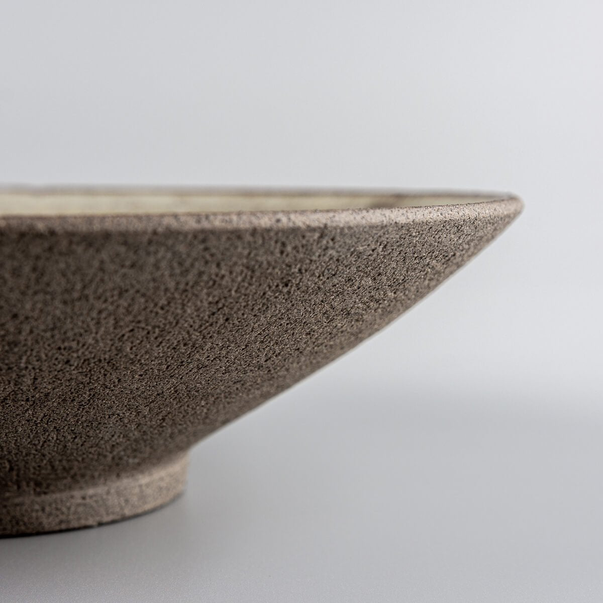 Artisan ceramic dinner plate base detail highlighting craftsmanship and stability.