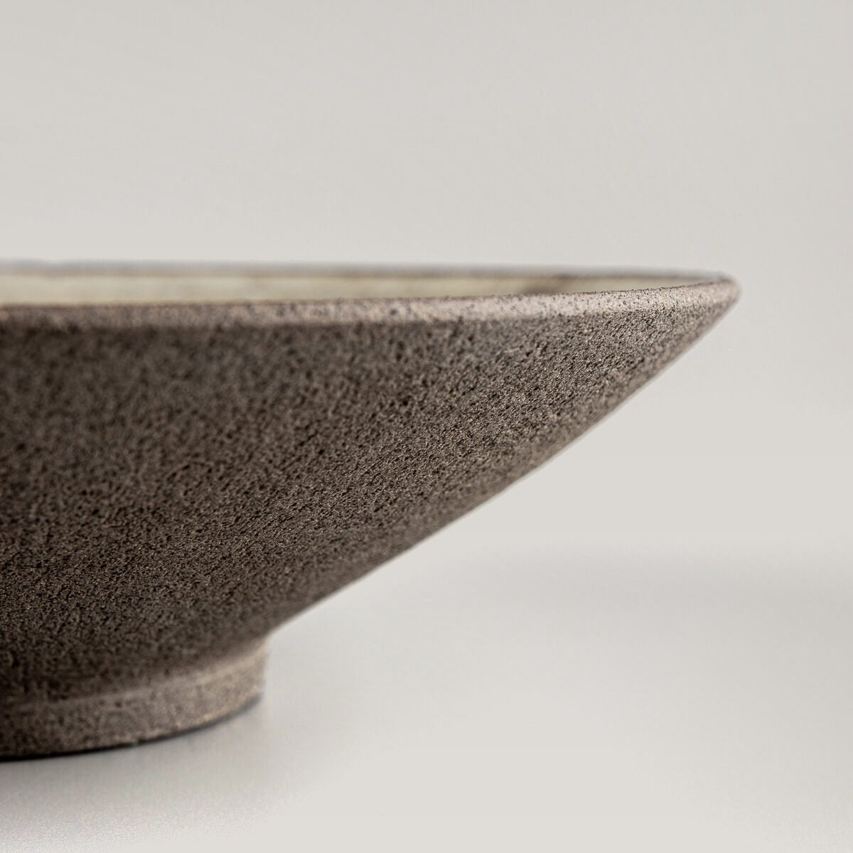 Artisan ceramic dinner plate base detail highlighting craftsmanship and stability.
