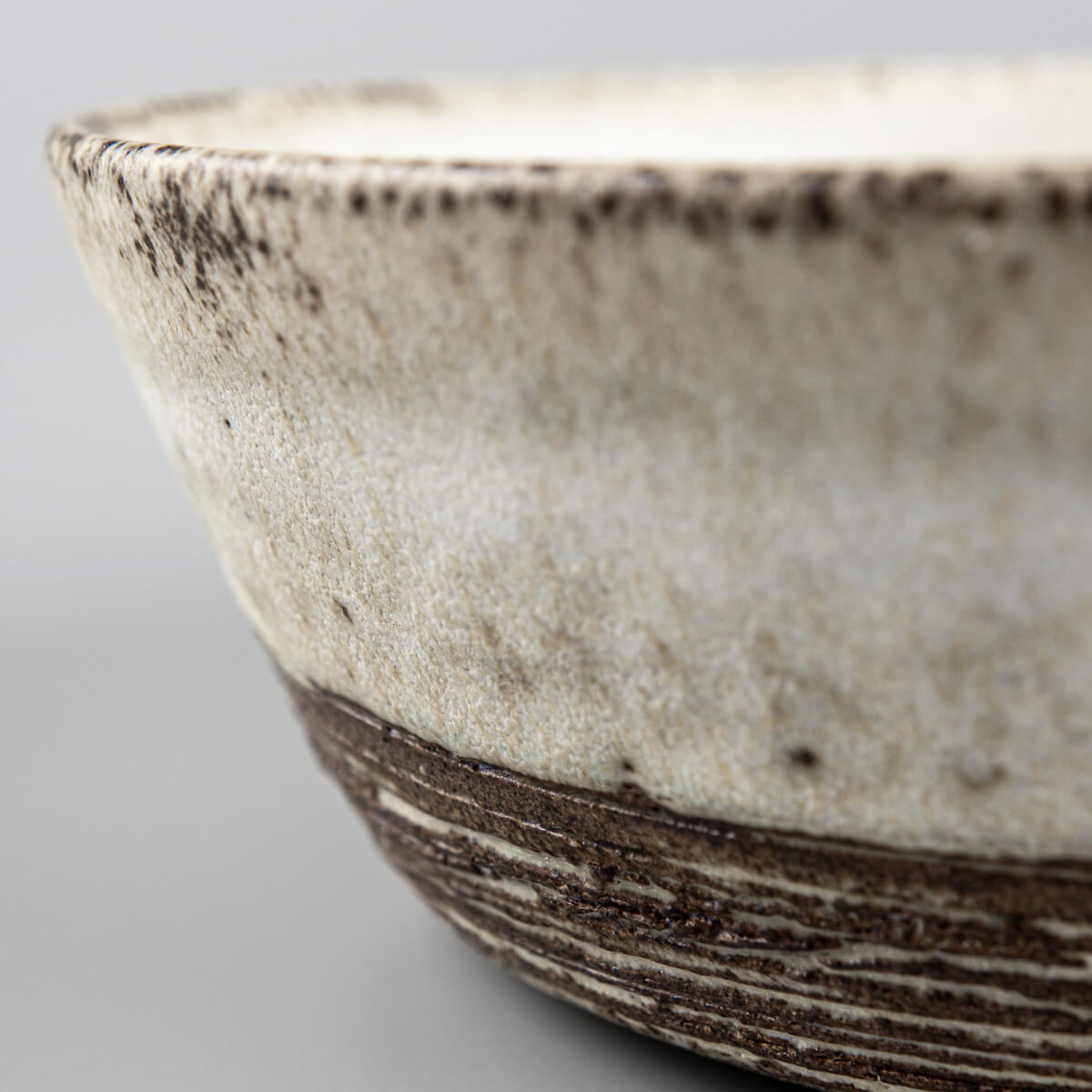 Handmade pottery bowl showcasing textural contrast and artisanal craftsmanship.