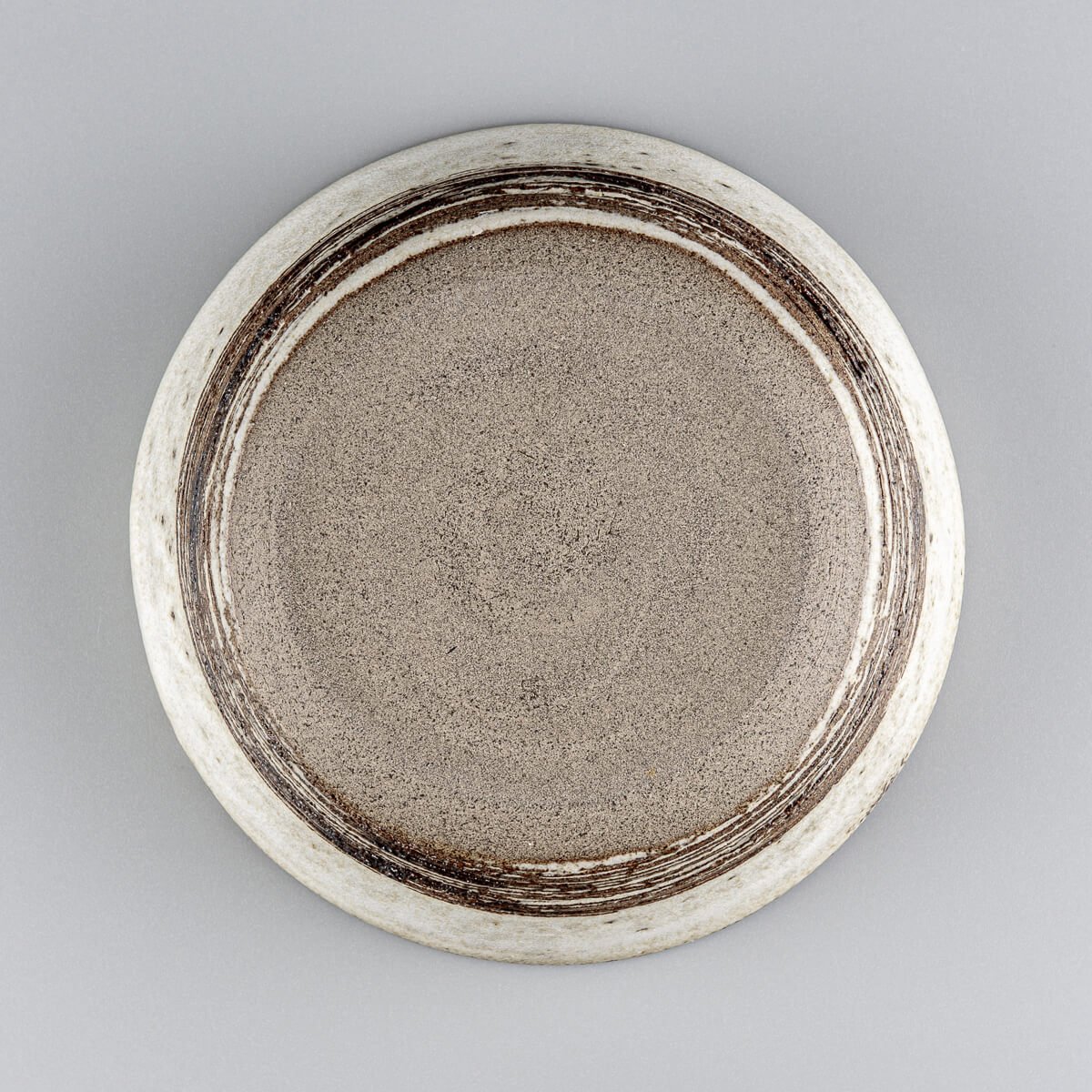 Bottom view of handmade bowl with signature concentric pattern and raw clay finish.