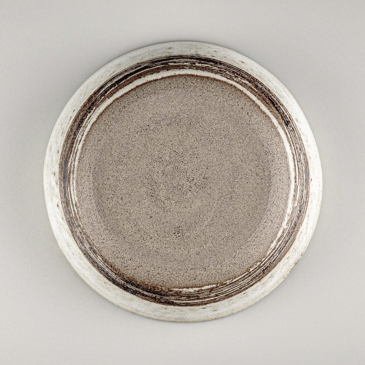 Bottom view of handmade bowl with signature concentric pattern and raw clay finish.