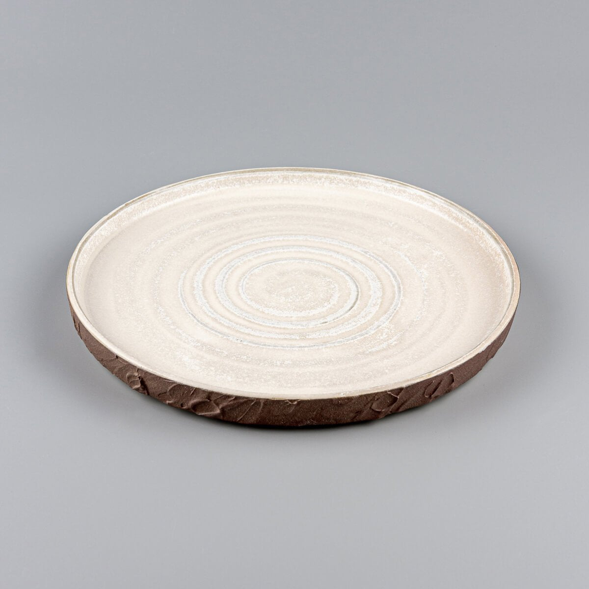 Artisanal pottery plate with iron oxide slip exterior and smooth matte white interior for gourmet meals.