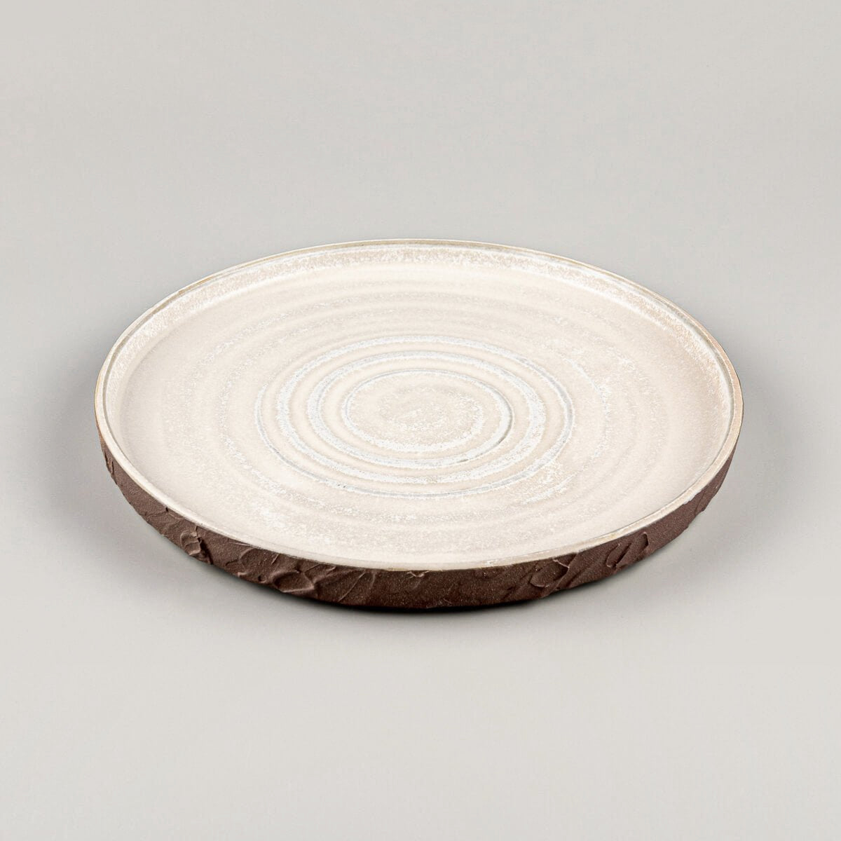 Artisanal pottery plate with iron oxide slip exterior and smooth matte white interior for gourmet meals.