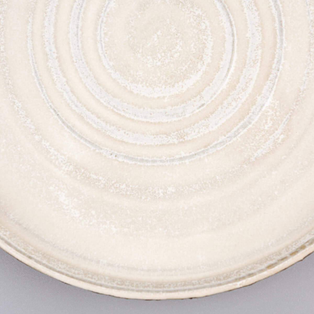 Detailed view of matte white glaze on artisanal pottery dinner plate for sophisticated tableware.