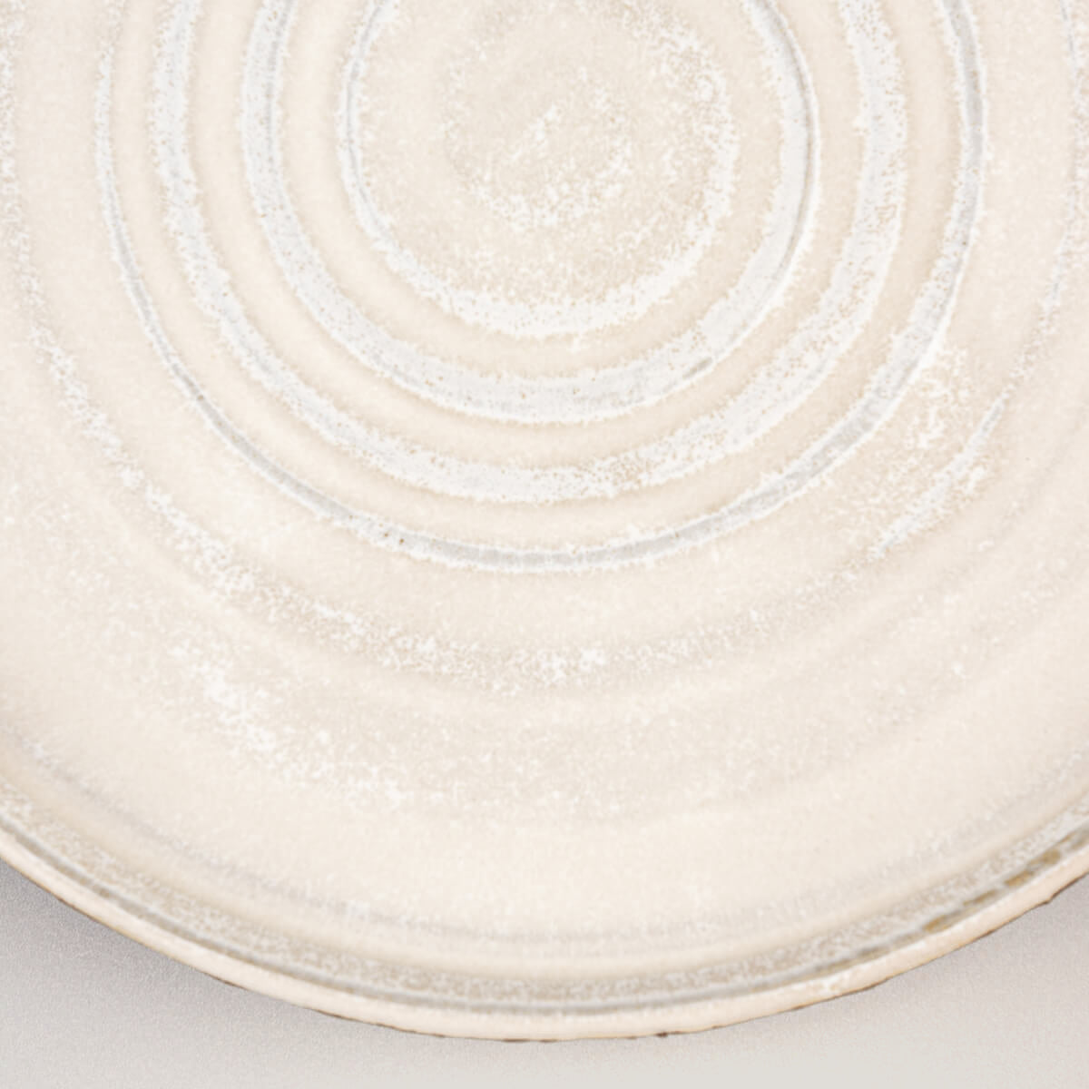 Detailed view of matte white glaze on artisanal pottery dinner plate for sophisticated tableware.