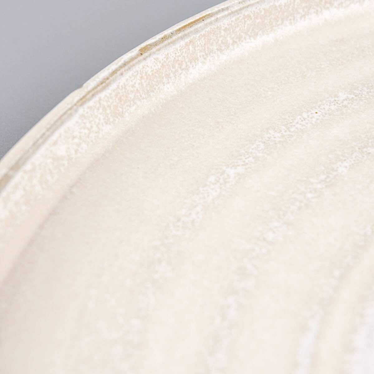 Flat-lay view of handmade stoneware plate with spiral center and smooth matte finish.