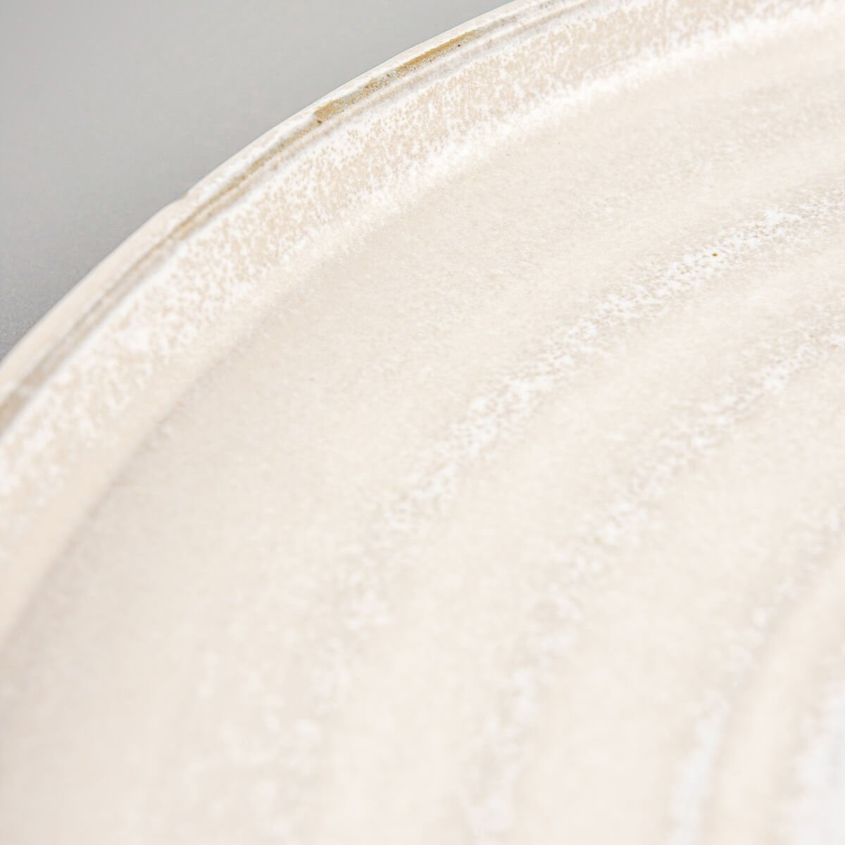 Flat-lay view of handmade stoneware plate with spiral center and smooth matte finish.