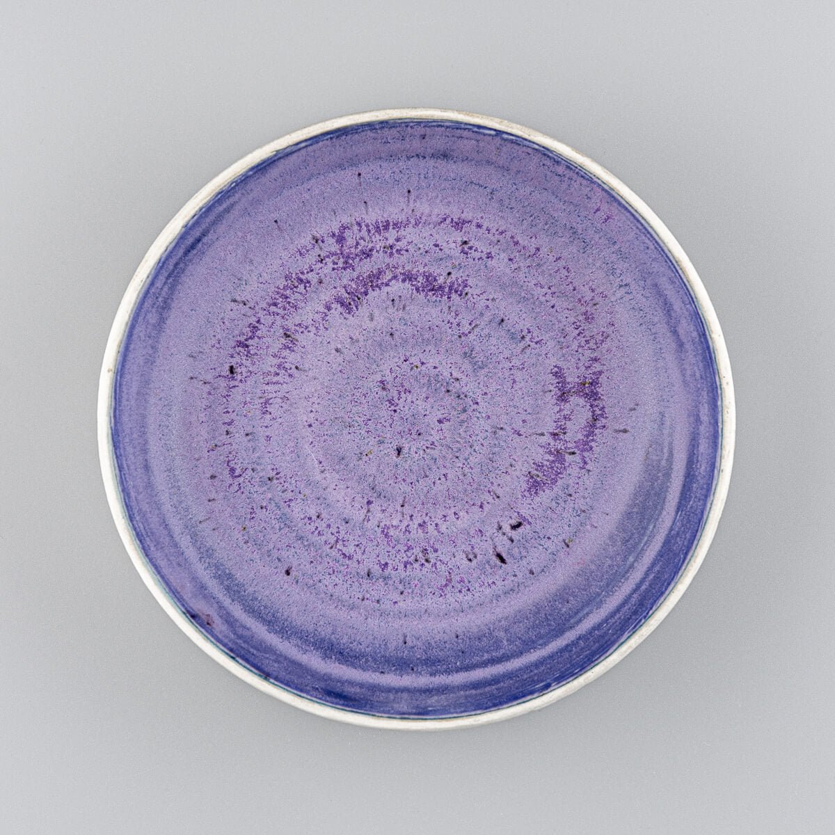 Top view of artisan ceramic bowl showing deep purple glazed interior and circular form.