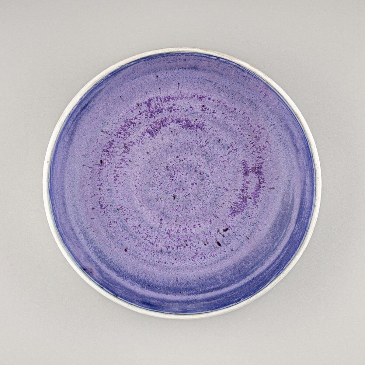 Top view of artisan ceramic bowl showing deep purple glazed interior and circular form.