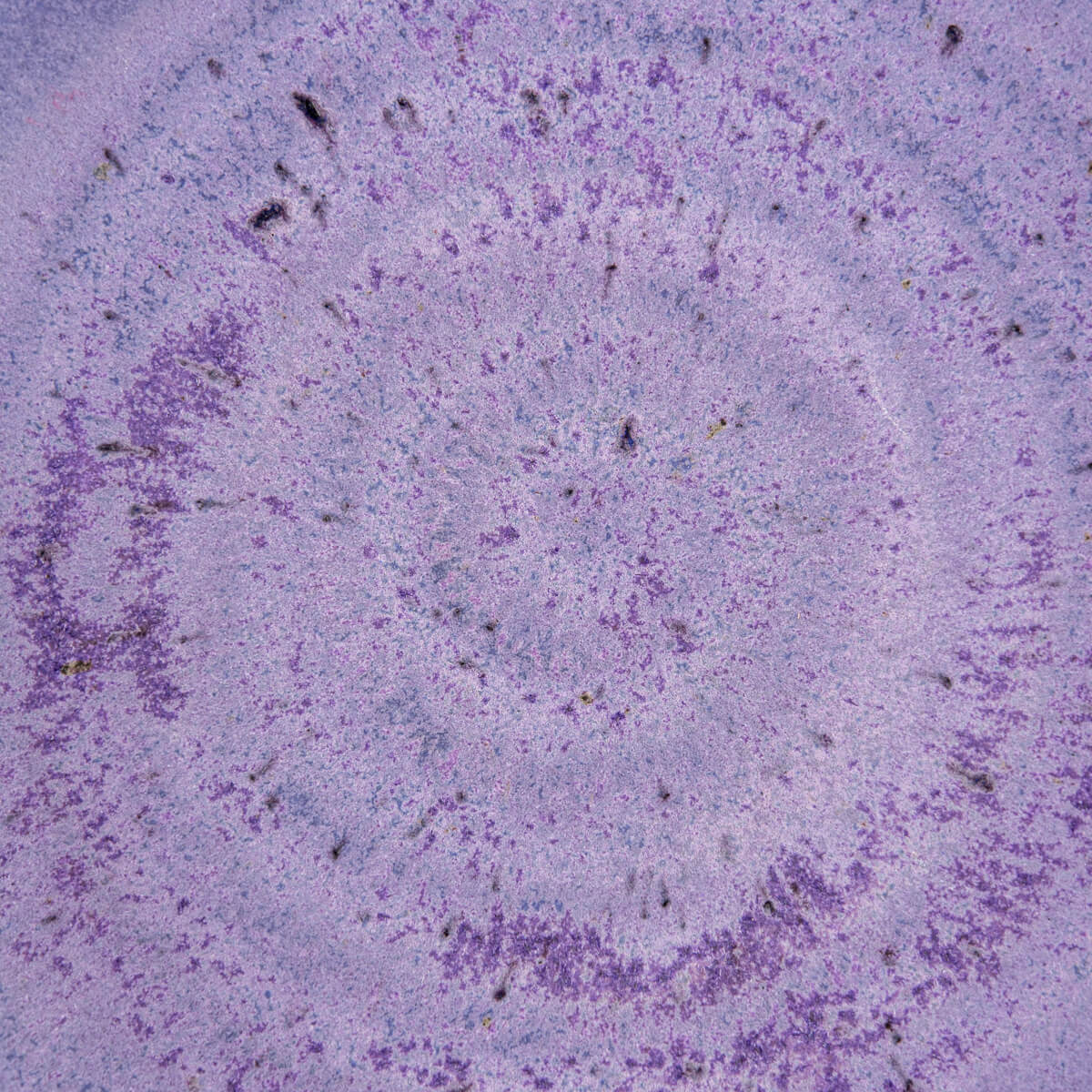 Close-up of deep purple glaze with handcrafted spiral design inside ceramic bowl.