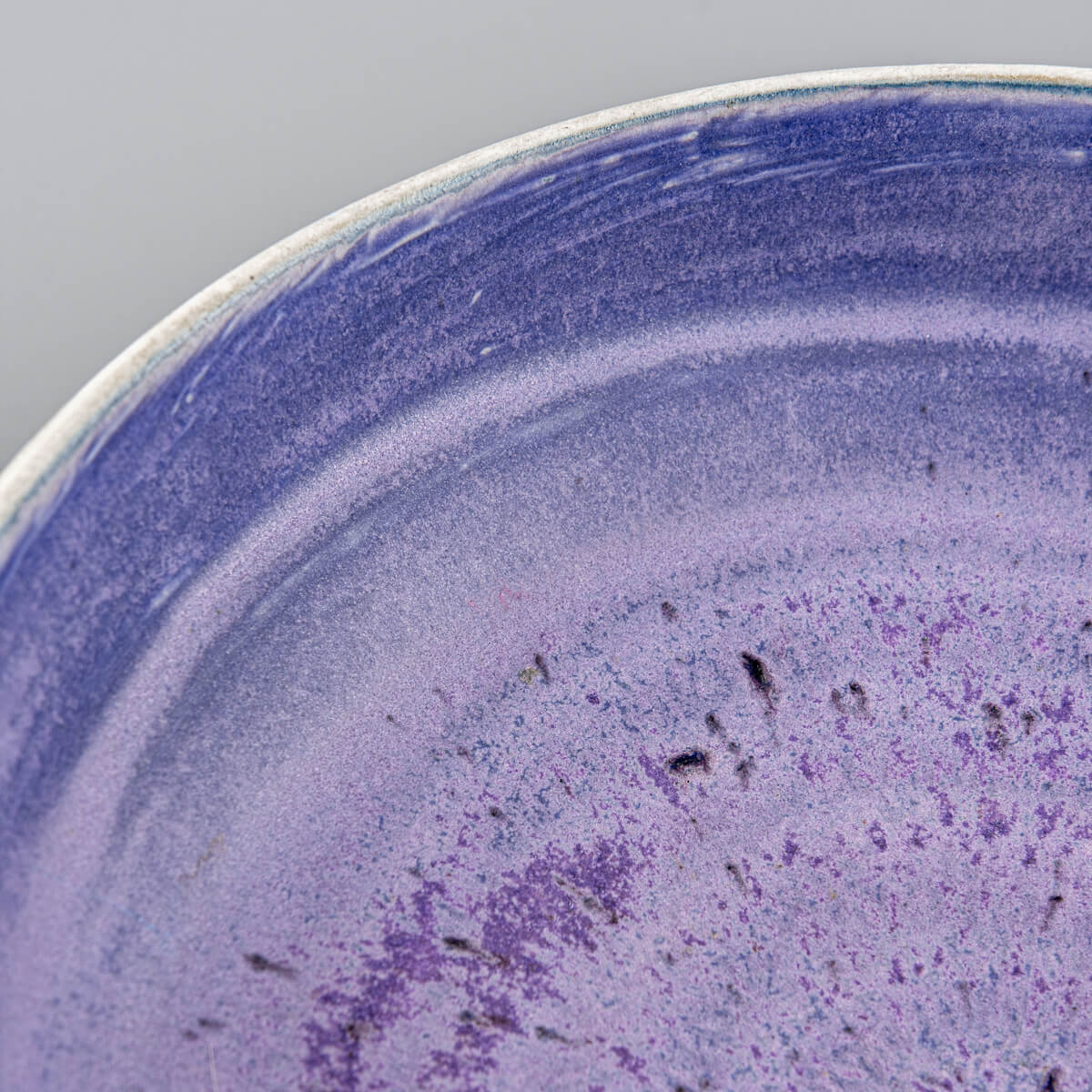 Oblique view of pottery bowl showing handmade surface details and glaze tones.