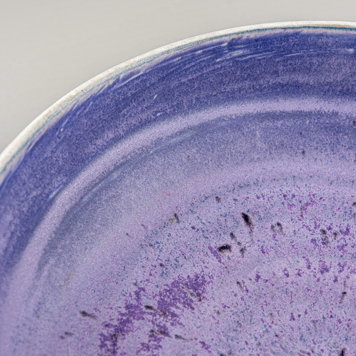 Oblique view of pottery bowl showing handmade surface details and glaze tones.