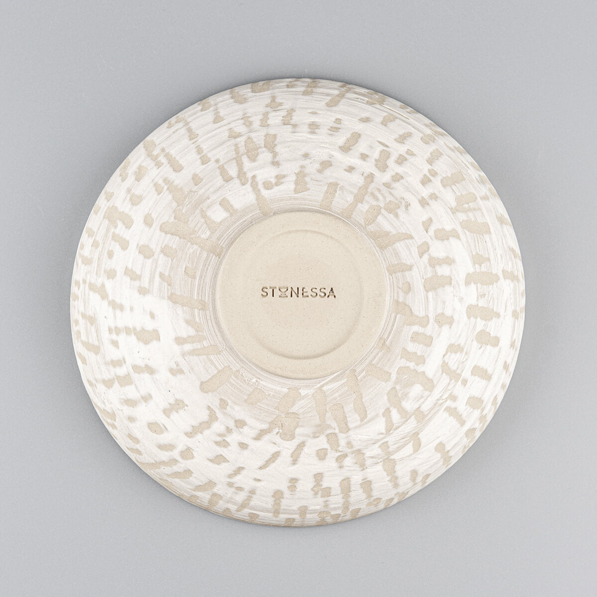 Detail of bottom of handmade ceramic bowl with natural finish and spiral foot ring.