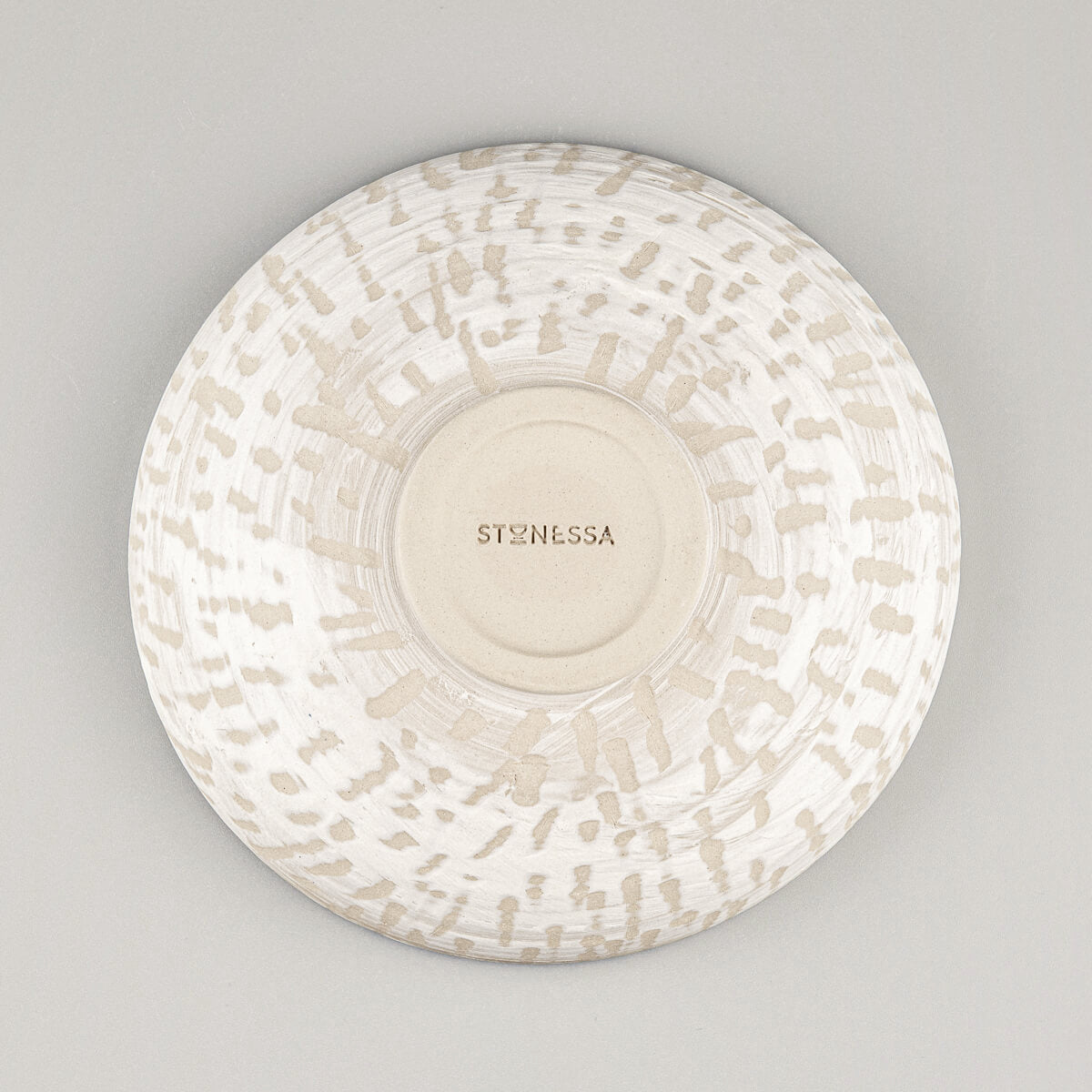 Detail of bottom of handmade ceramic bowl with natural finish and spiral foot ring.