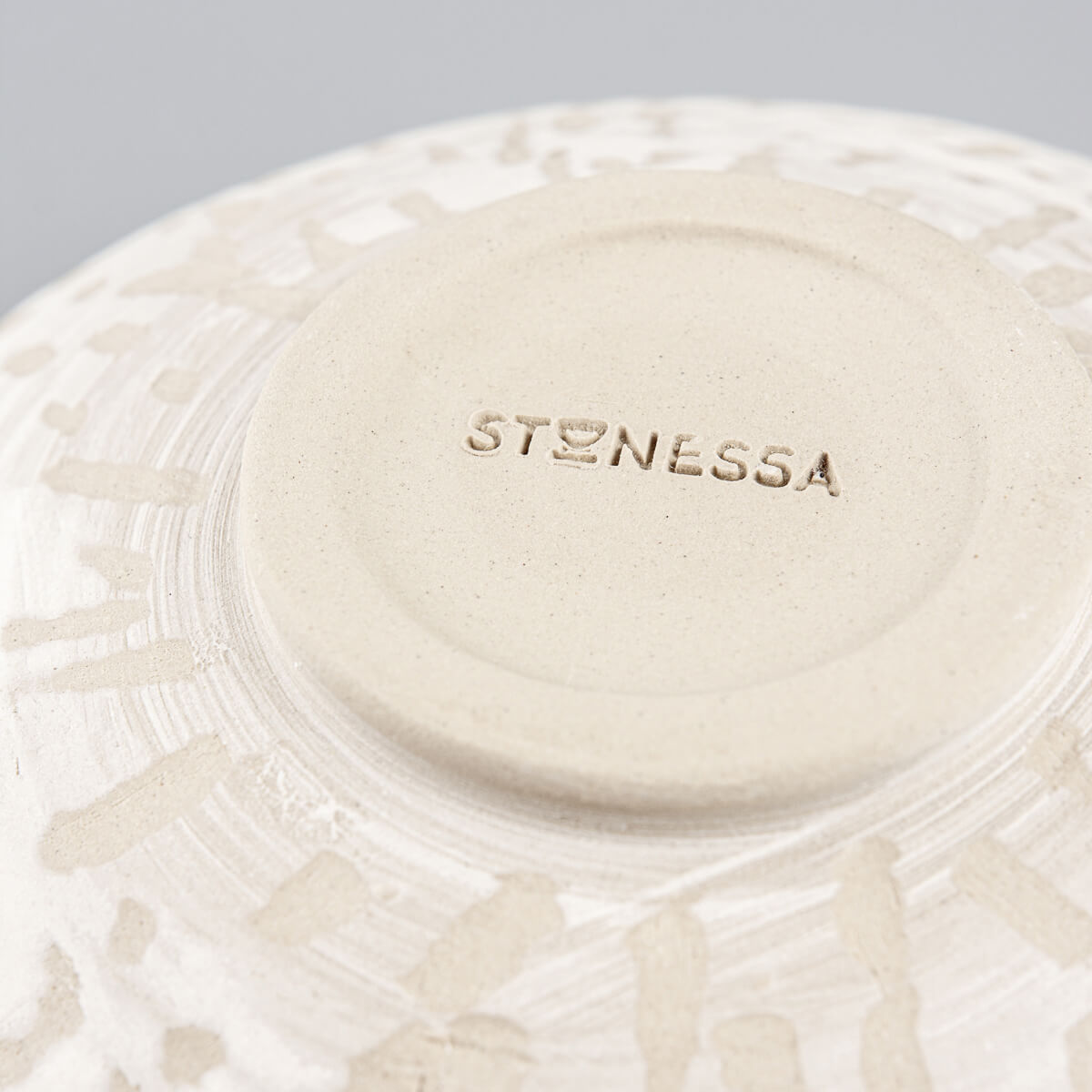 Close-up of textured slip pattern on outer surface of stoneware pottery bowl.