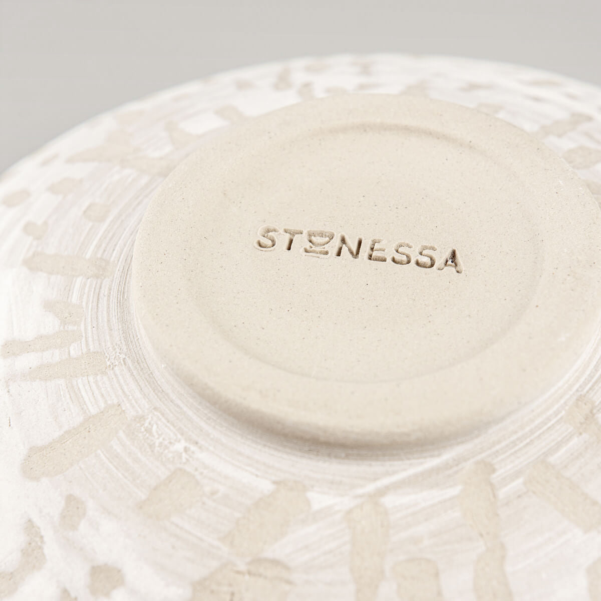 Close-up of textured slip pattern on outer surface of stoneware pottery bowl.