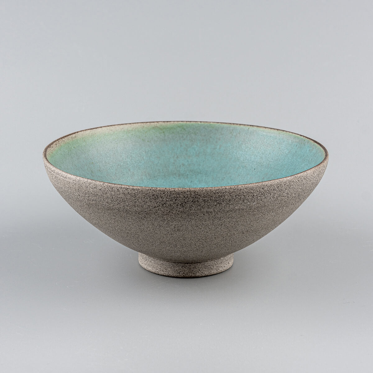 Angled front view of handcrafted ceramic bowl with unglazed textured finish.