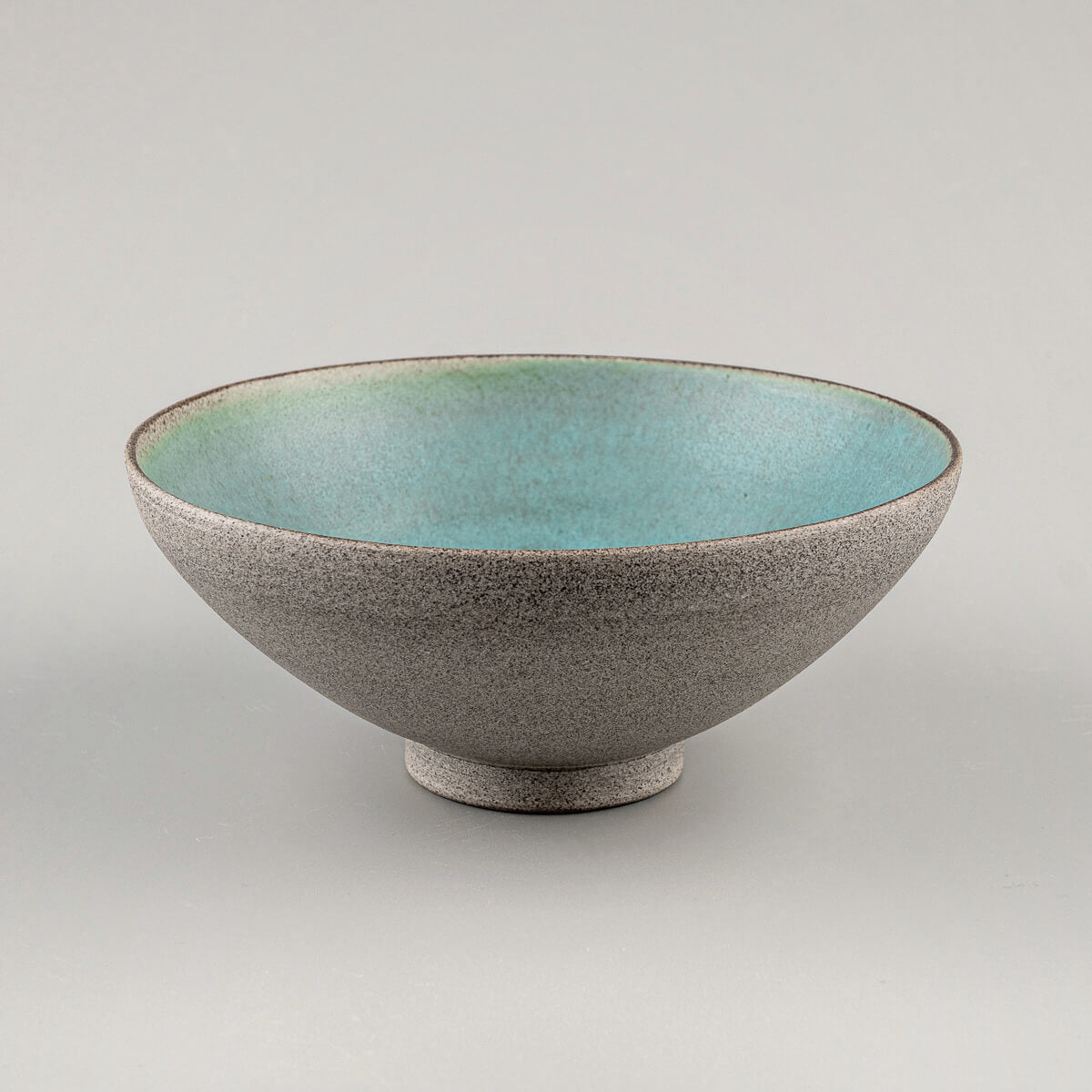 Angled front view of handcrafted ceramic bowl with unglazed textured finish.