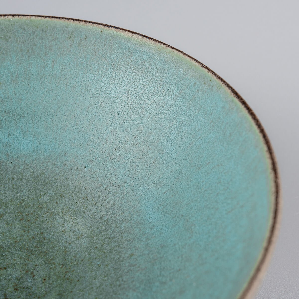 Close-up showing deep aqua tones and handcrafted brush marks on ceramic.