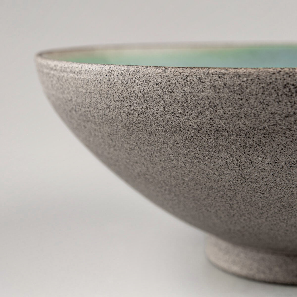 Textured outer surface of ceramic bowl revealing natural unglazed clay.