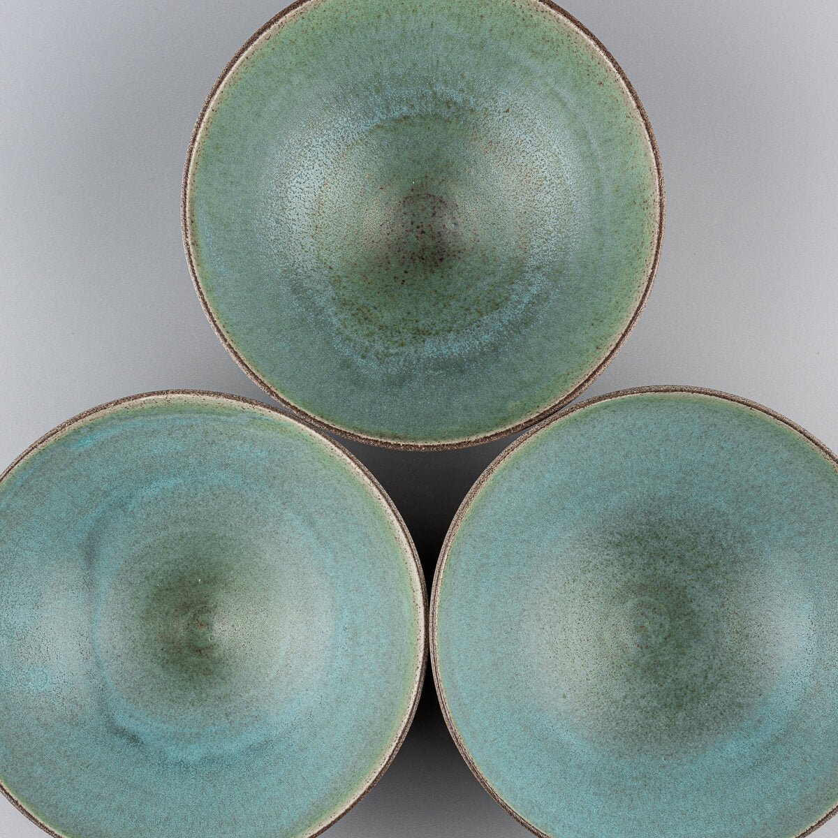 Grouped view of three handmade ceramic bowls showcasing natural variations.
