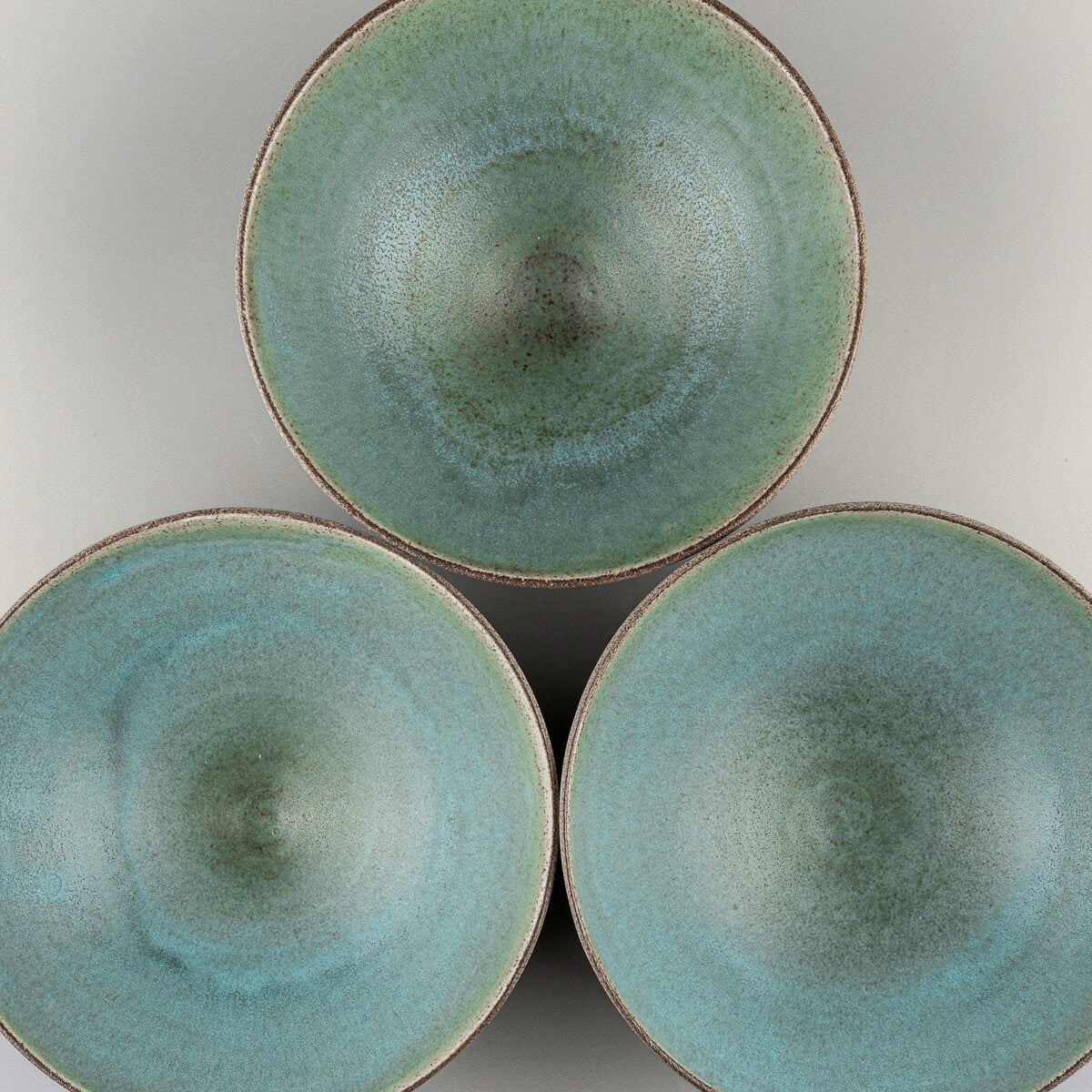 Grouped view of three handmade ceramic bowls showcasing natural variations.
