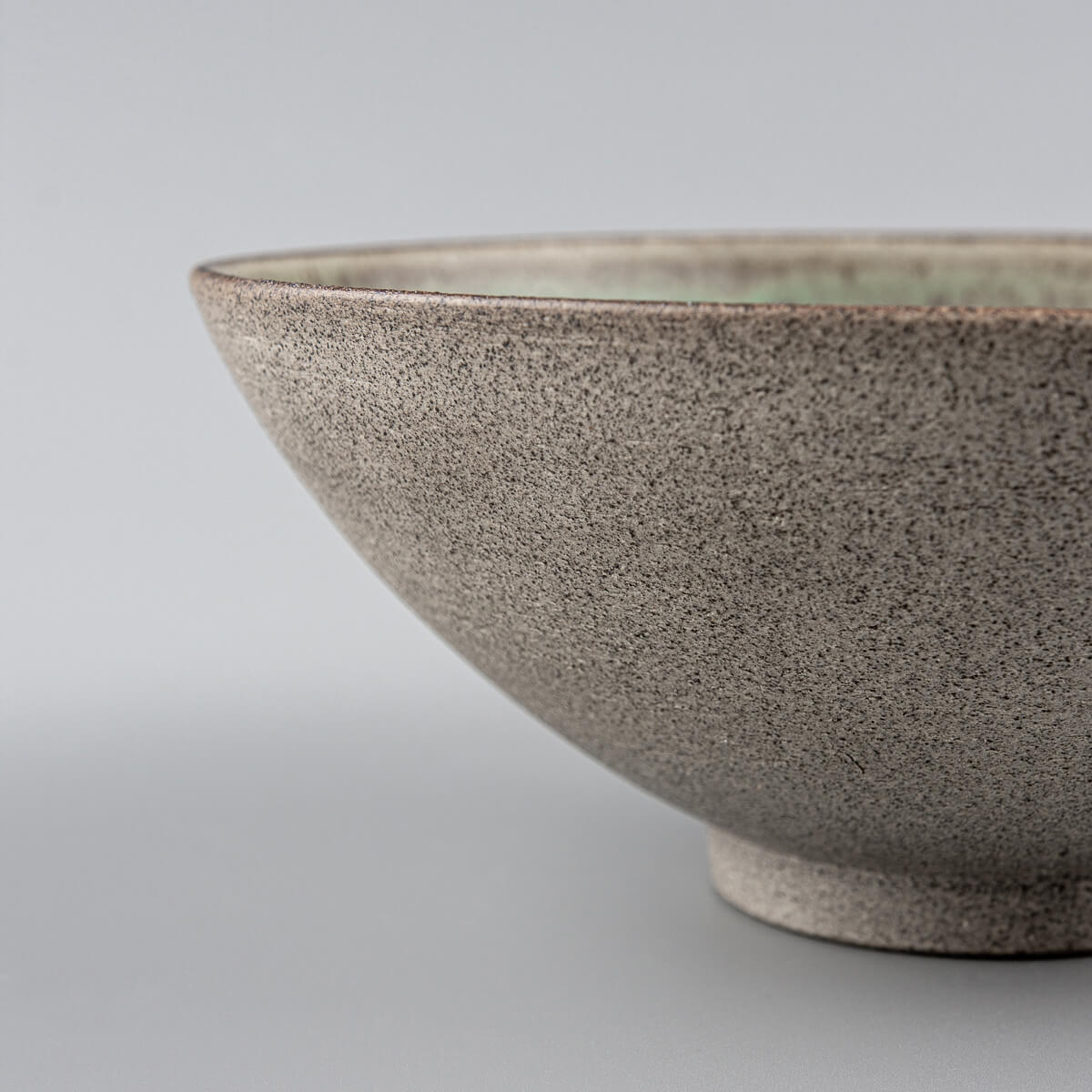 Profile view of handmade bowl with smooth curvature and stable ceramic base.