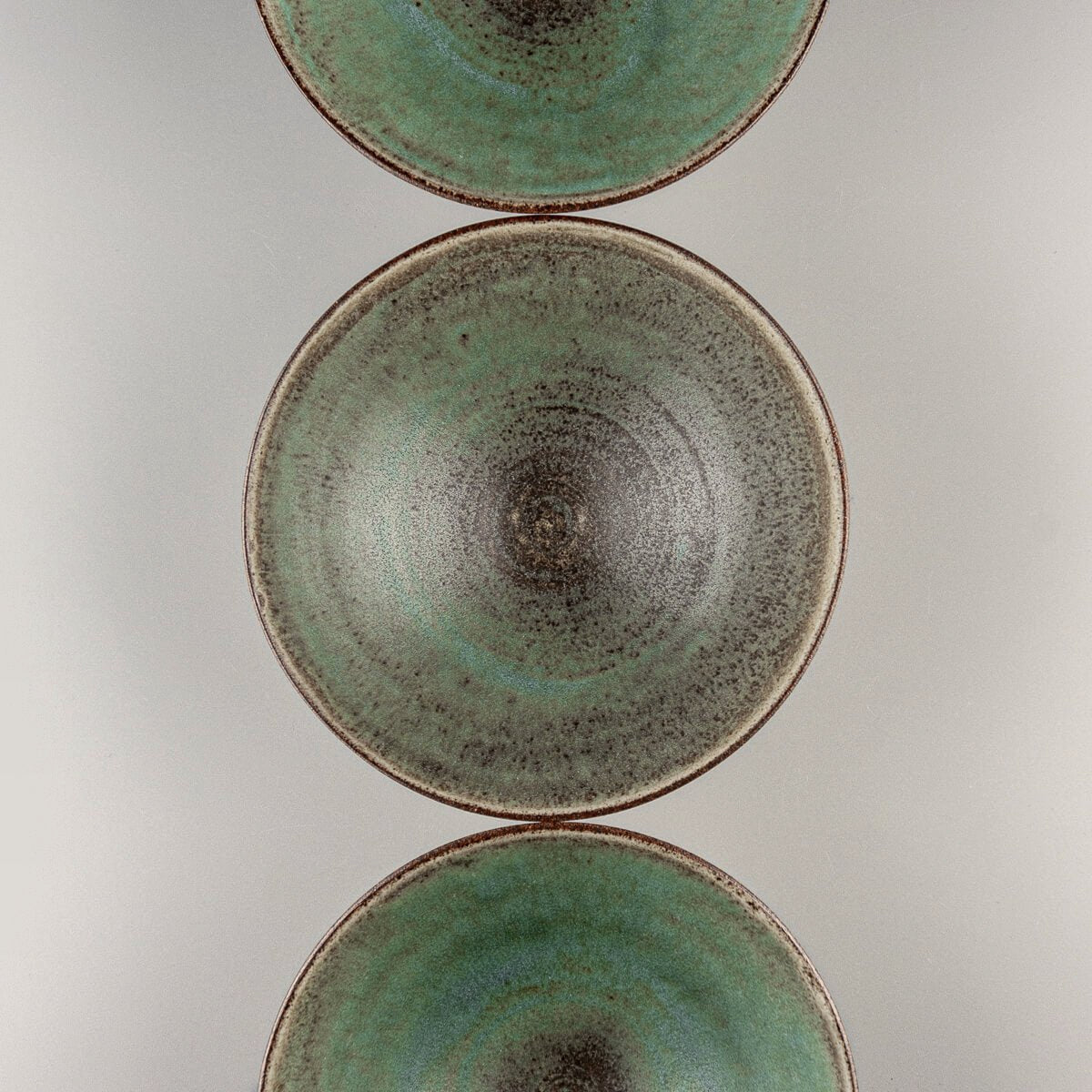 Collection of green interior ceramic bowls for home, gift, or collectible tableware.