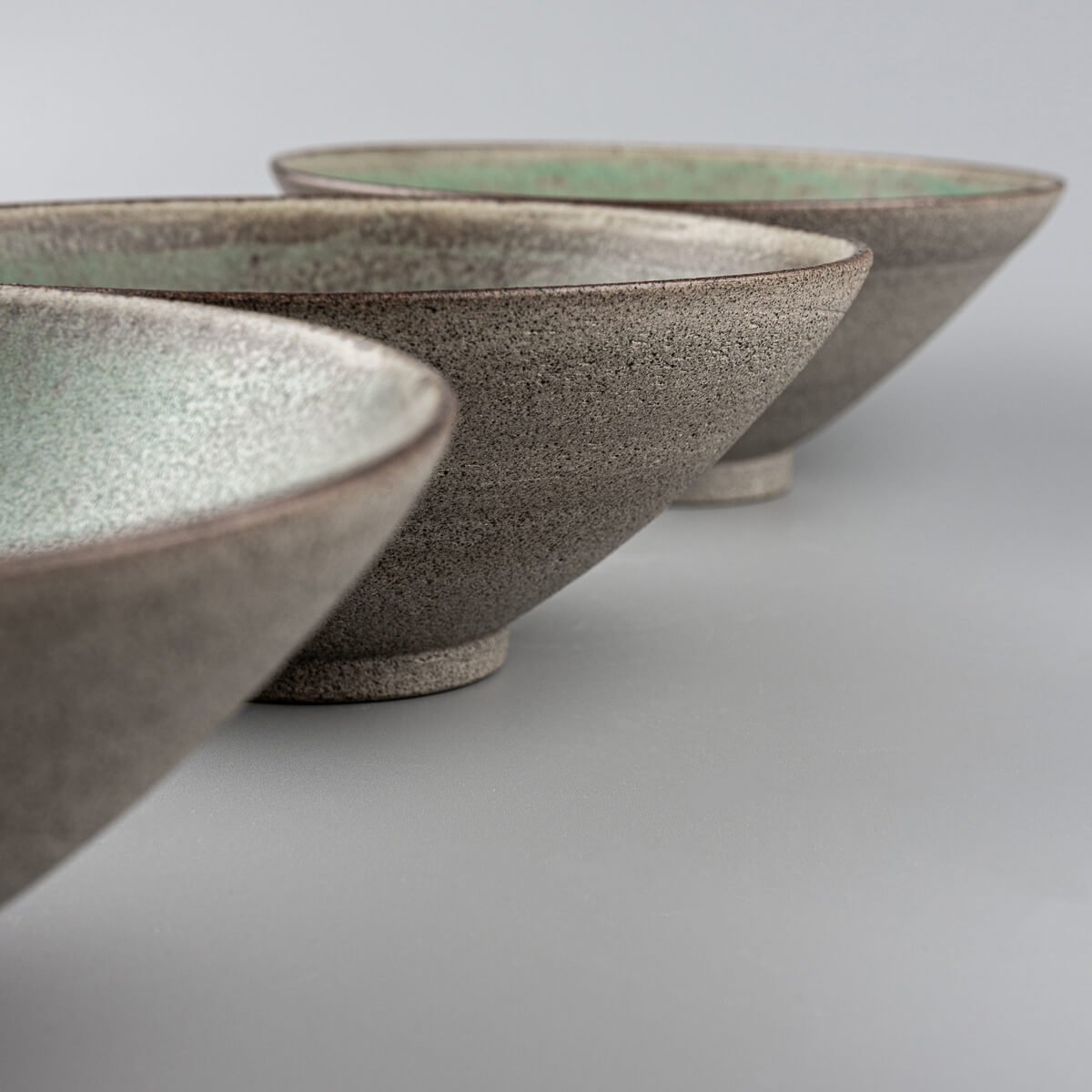 Detail of stacked ceramic bowls with interior glaze and exterior raw finish.