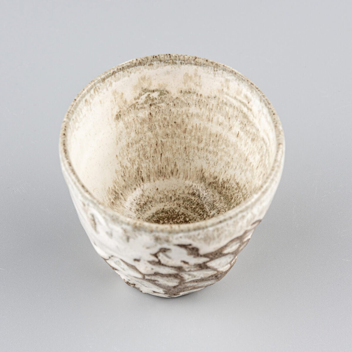 Top view of artisanal ceramic mug with matte glaze and carved surface, perfect for matcha tea, coffee, or fine dining.