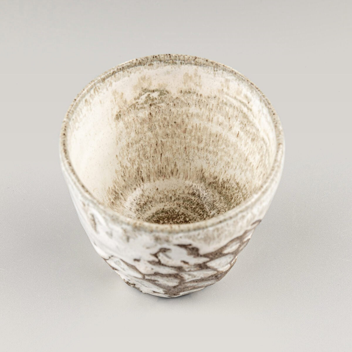 Top view of artisanal ceramic mug with matte glaze and carved surface, perfect for matcha tea, coffee, or fine dining.