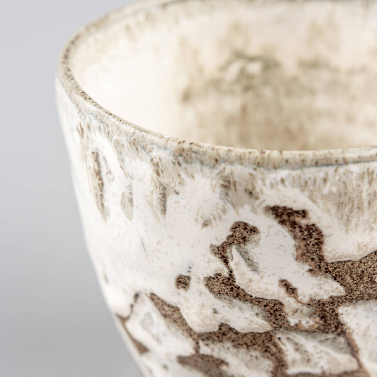 Rustic ceramic mug with white matte glaze and natural clay texture for restaurants and culinary presentation.