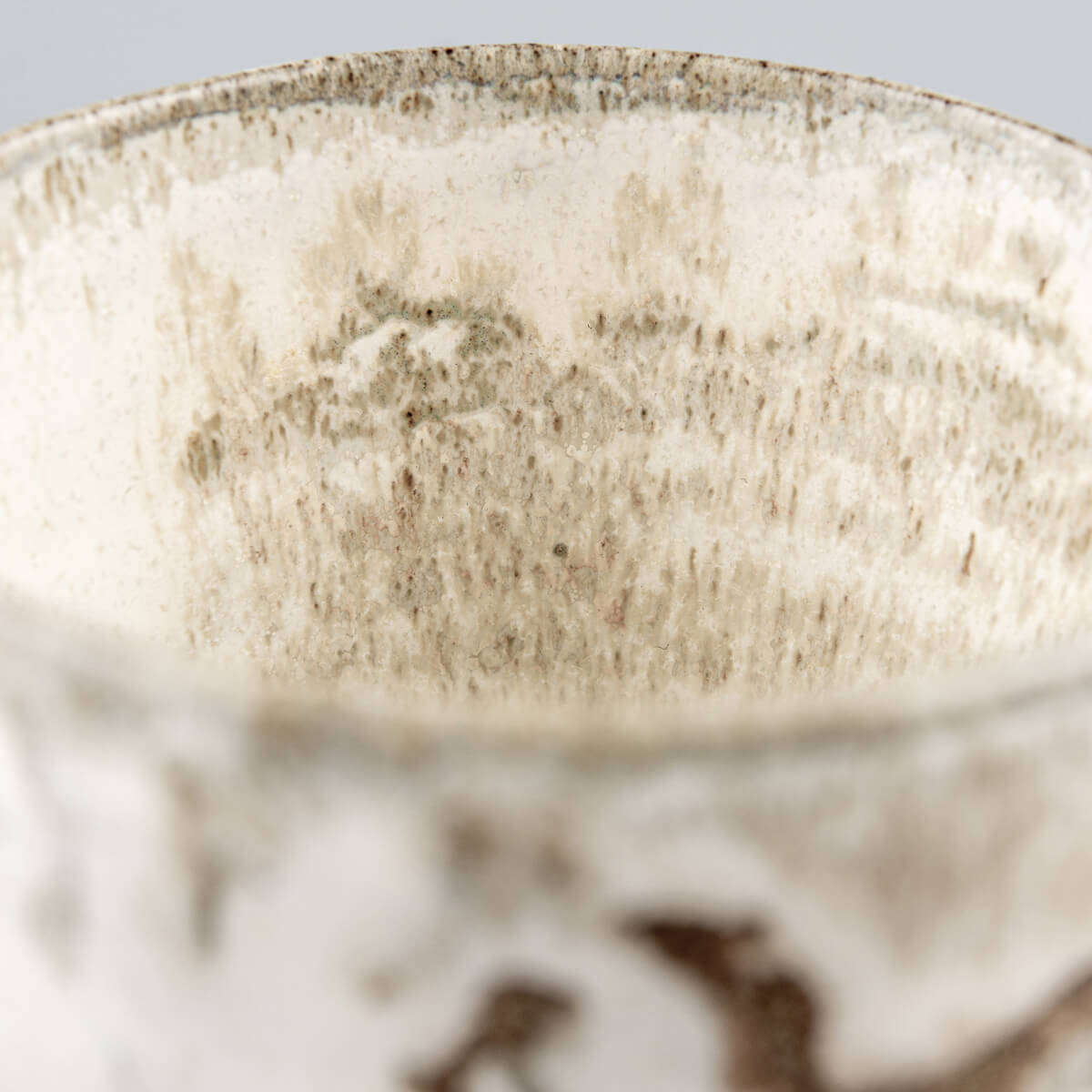 Luxury handmade ceramic mug rim close-up with rustic glaze texture, collectible pottery for chefs and interior design.