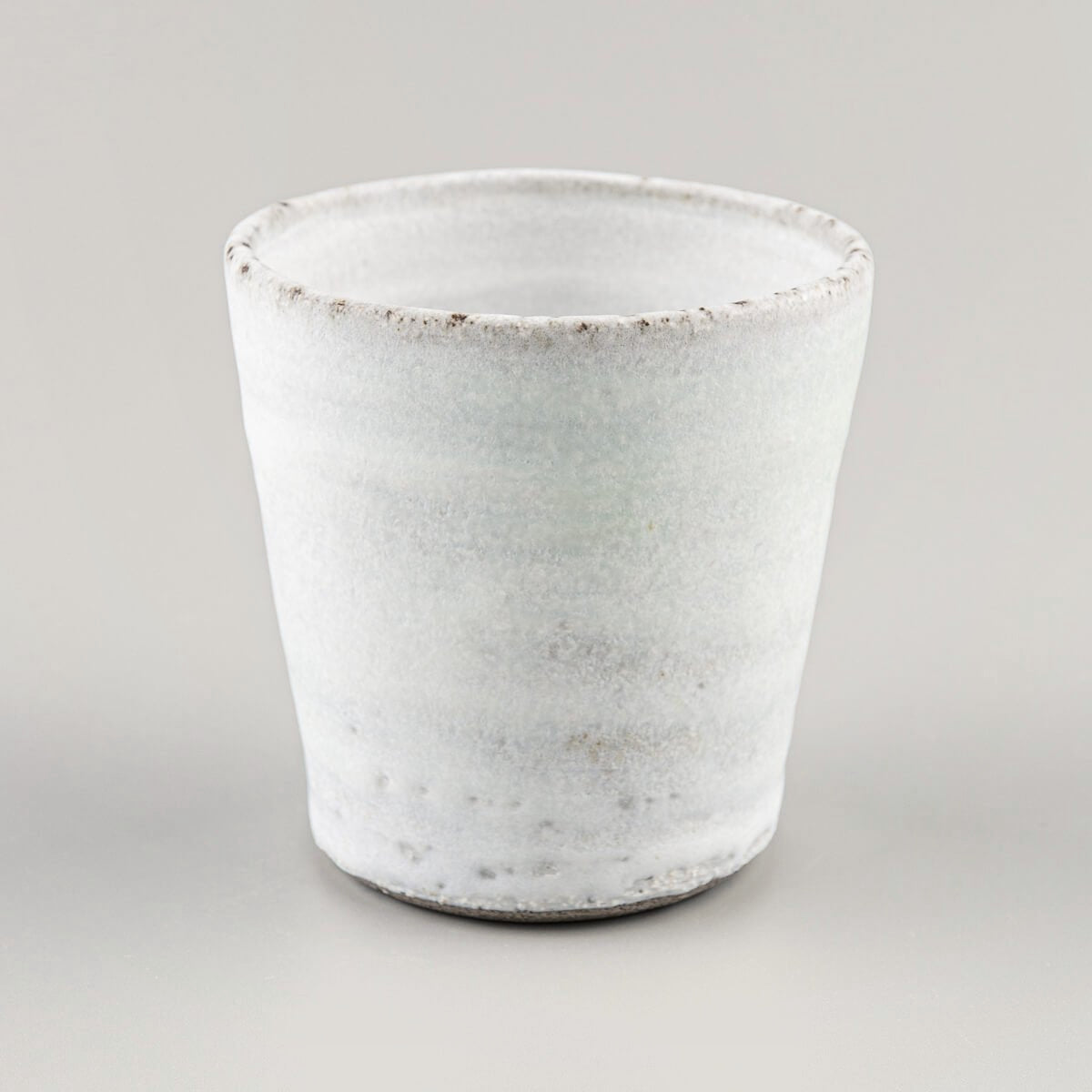 Elegant handmade ceramic mug with natural texture and beveled base for everyday kitchenware.