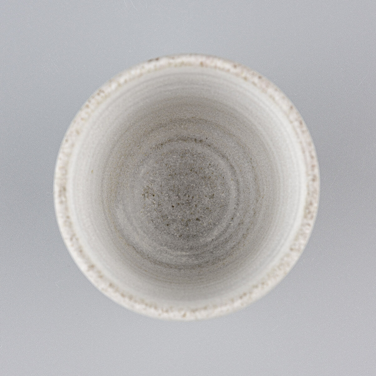 Top view of a handmade stoneware mug with matte glaze, ideal for modern culinary presentation.
