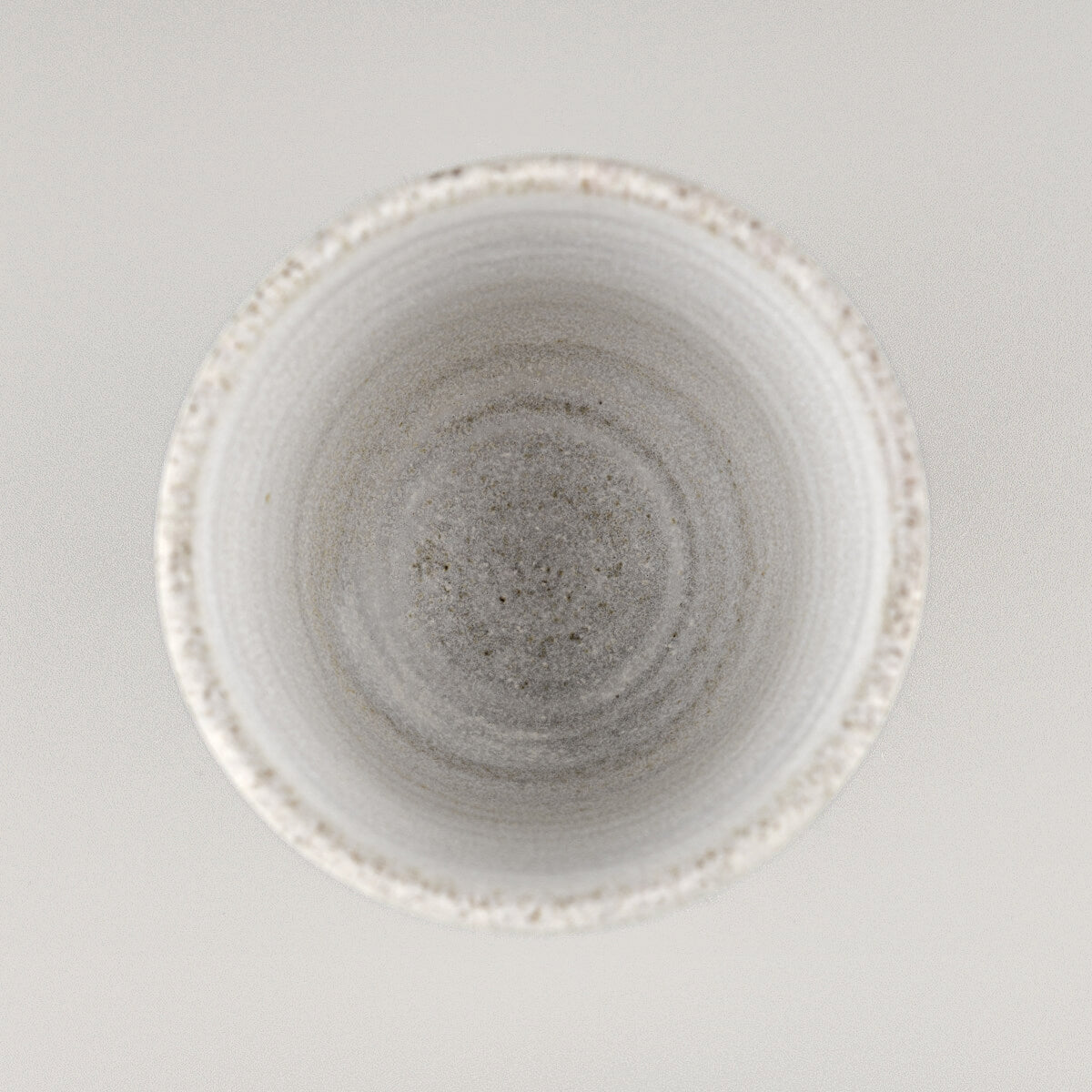 Top view of a handmade stoneware mug with matte glaze, ideal for modern culinary presentation.