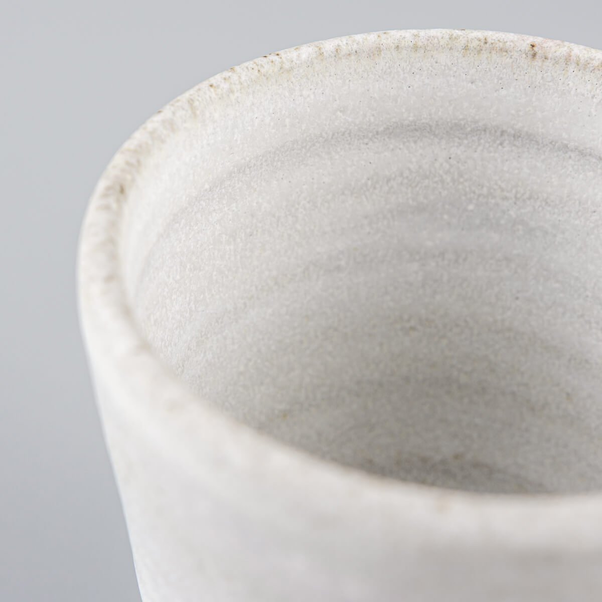 Detail of artisanal ceramic mug with soft glaze finish for fine dining and collectible pottery.