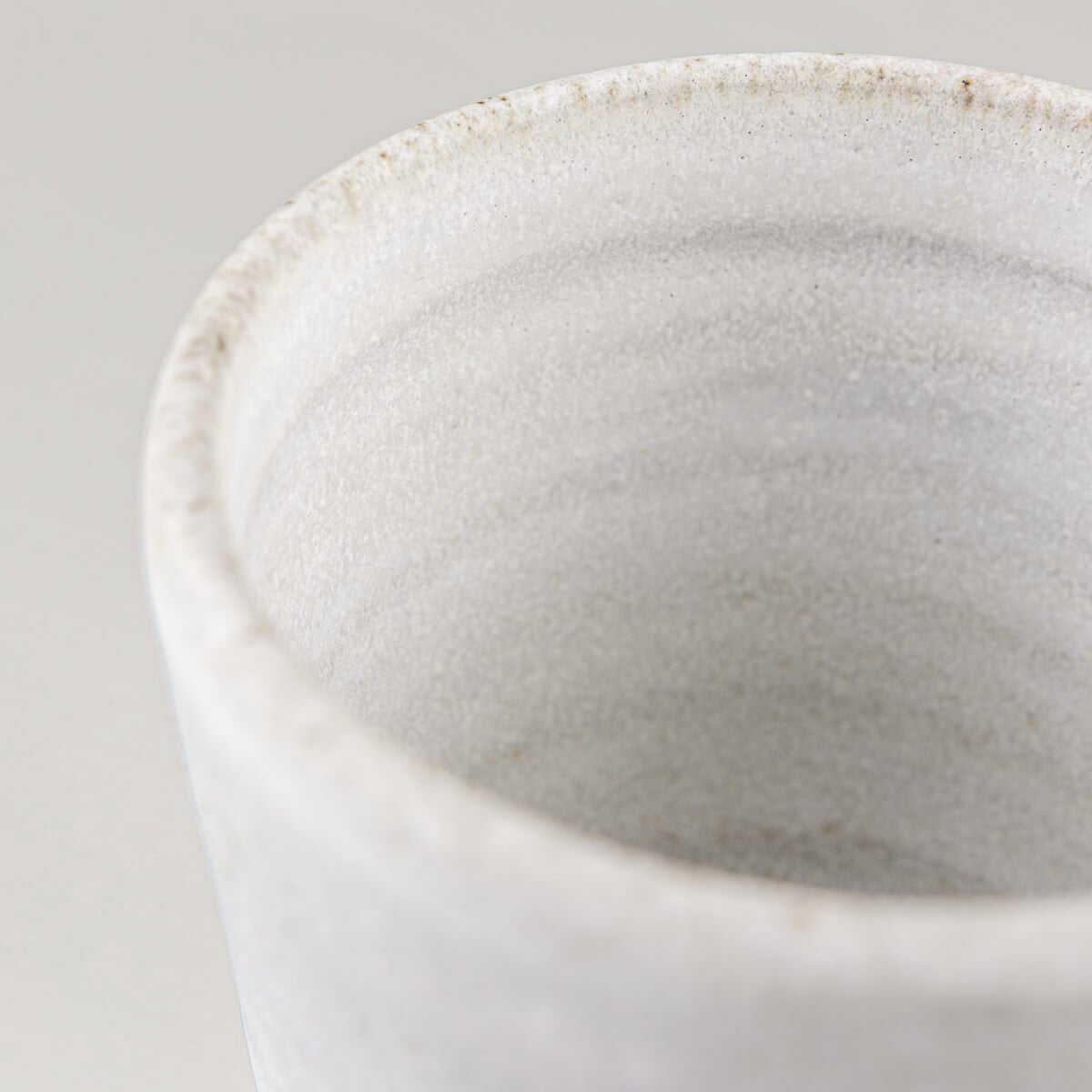 Detail of artisanal ceramic mug with soft glaze finish for fine dining and collectible pottery.