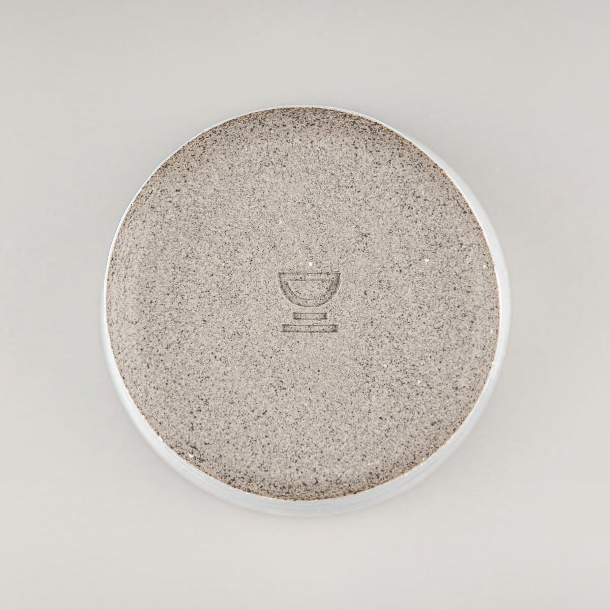 Bottom of artisanal ceramic mug with handmade finish, perfect for collectible tableware.