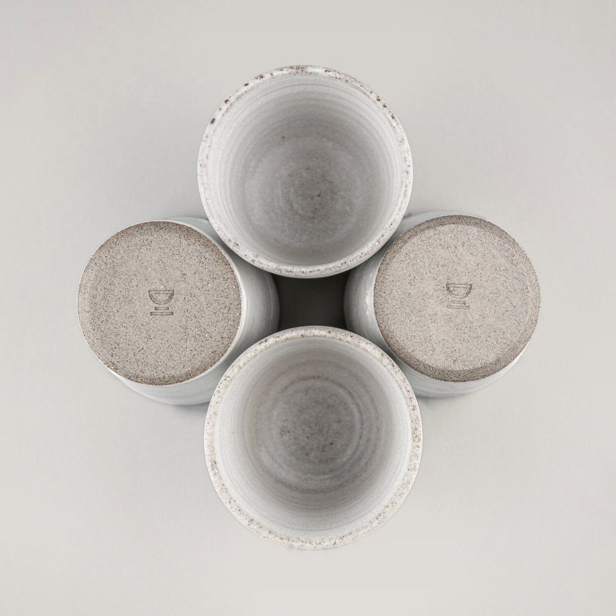 Four handmade stoneware mugs arranged for modern kitchen and boutique restaurant use.