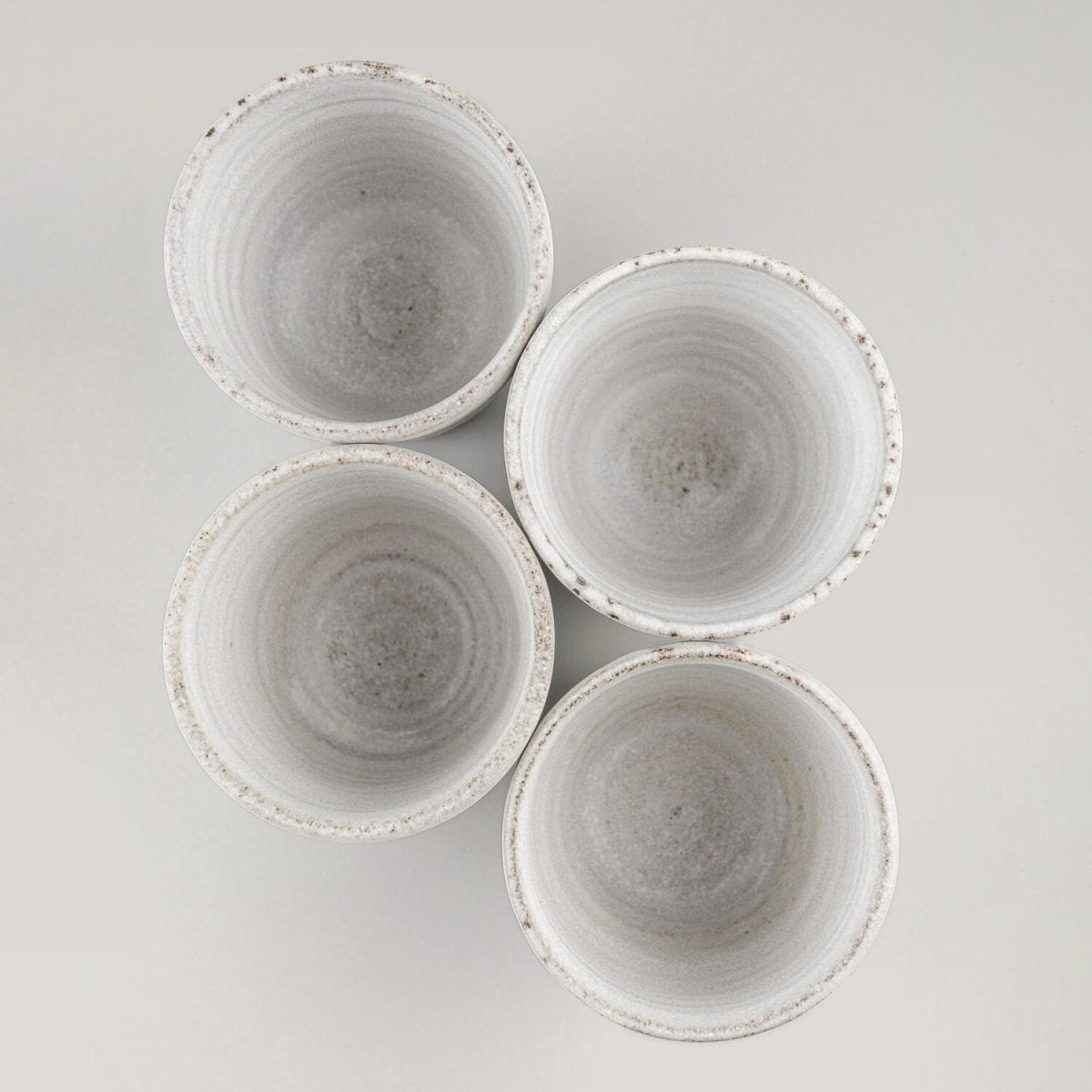 Set of handmade ceramic mugs with white matte glaze for coffee, tea, and home interiors.