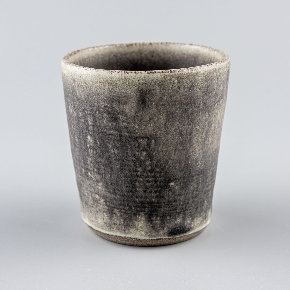 Rustic handmade ceramic cup with hakeme texture and olive-green glaze for modern kitchenware and tableware presentation.