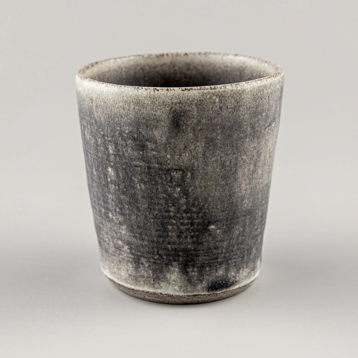 Rustic handmade ceramic cup with hakeme texture and olive-green glaze for modern kitchenware and tableware presentation.