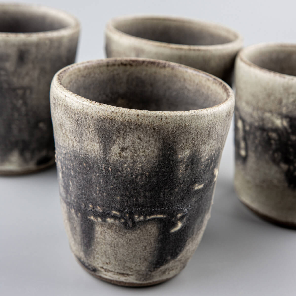 Set of four pottery cups with rustic glaze and textured finish, designed for fine dining and boutique interiors.