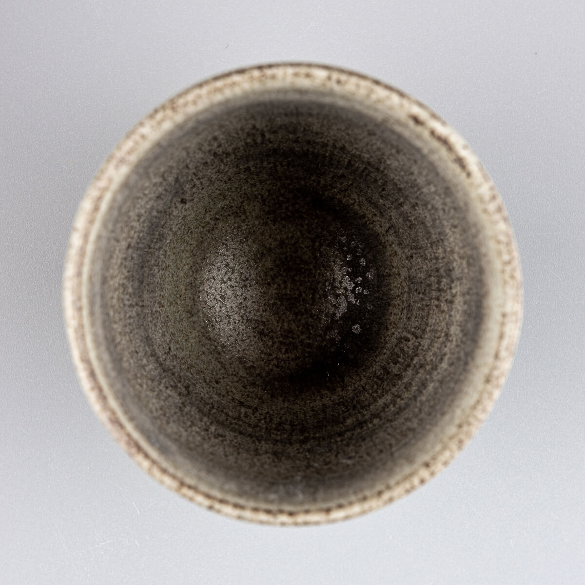 Top view of artisanal pottery cup with unique glaze finish, perfect for tea, coffee, and collectible stoneware.